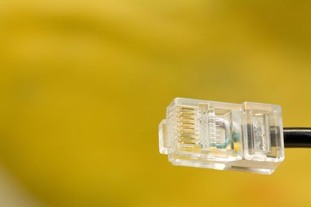 Single RJ45-Plug. Close-Up, yellow background. Copyspace.の写真素材