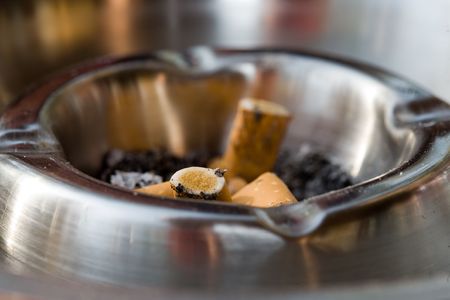 Close-up of an metal ashtray with squeezed cigarettes. Variationの写真素材