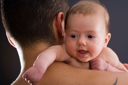 Infant looking over his fathers shoulderの写真素材