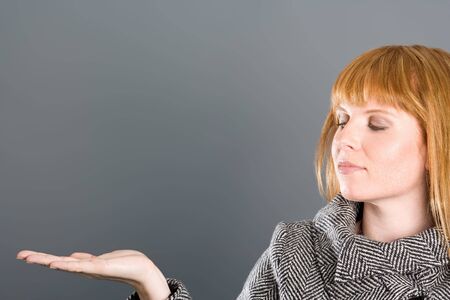 Woman in coat with outstretched hand.の写真素材