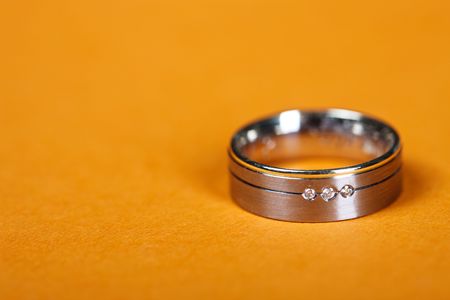 Single Wedding ring with diamonds, on orange background