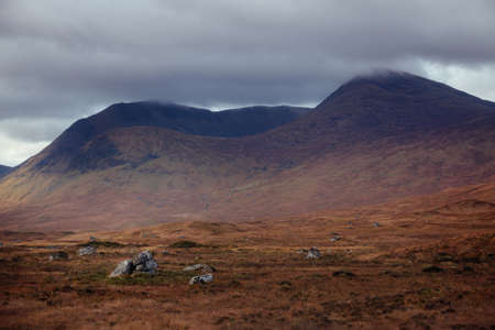 Scotland highland rocky plateau. Mountain covered with clouds. Scenic landscape dramatic autumn season viewの写真素材
