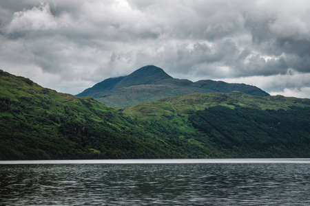 Scottish landscape with lake view and clouds covered green mountains. Summer 2019. Loch Lomond, Scotlandの写真素材