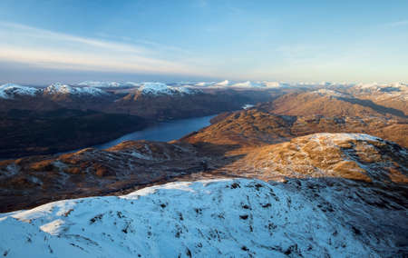 Snow covered mountain peaks and lake at sunset. Loch Lomond and The Trossachs National Park. Scotlandの写真素材