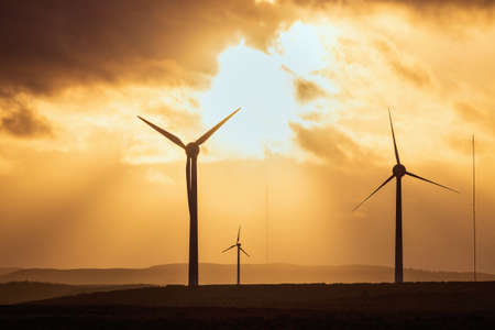 Windmills in a field at sunset on the background of dramatic sky. West Lothian, Scotland, UKの写真素材