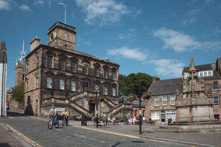 LINLITHGOW, UNITED KINGDOM - JUNE 19, 2020: People have a rest on a city square during lockdown due to epidemic COVID-19. It is historically West Lothian's county townのeditorial素材