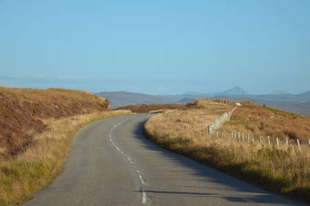 Curved mountain road and fence on Isle of Skye, Scotland.の写真素材