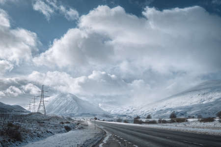 Winter road through Scottish Highlands and snowy mountains. Scotland, United Kingdomの写真素材