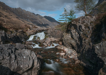 Waterfall on the rocky River Coe and and a spruce tree. Glencoe Mountain, Scotland, United Kingdomの写真素材