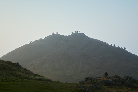 People watching cityscape in the top of hill. Arthurs Seat, Edinburgh, Scotland, United Kingdomの写真素材