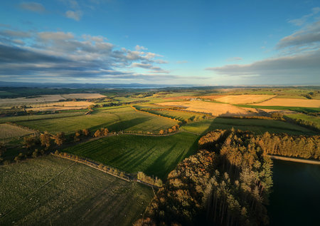 Aerial view of countryside fields and green hills at sunset. Beautiful rural landscape and nature background. Beecraigs Country Park, West Lothian, Scotlandの写真素材
