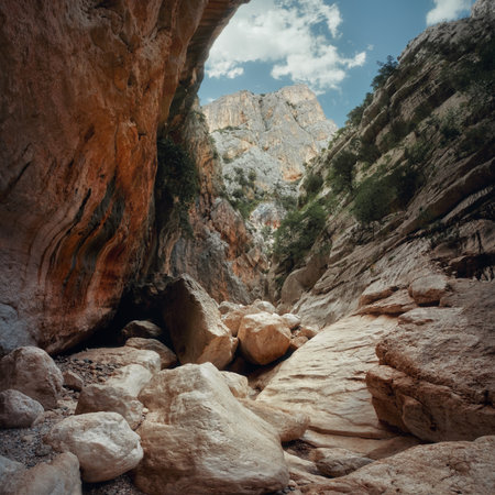 Dramatic view of Gorropu Canyon in Sardinia with massive boulders, steep limestone walls and rugged geological textures under a bright sky. Wild Mediterranean landscape.の写真素材