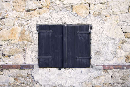 Wooden shutters on the background of the stone walls, architectural detailの写真素材