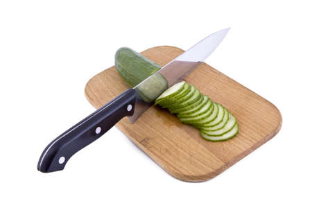 Fresh green cucumber with a kitchen knife and cutting boardの写真素材