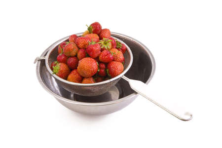 Fresh tasty strawberries in a colander isolated on whiteの写真素材