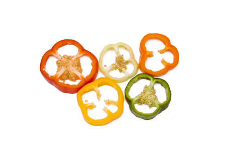 Mixed pieces of different colored paprikas isolated on white, sports competition circlesの写真素材