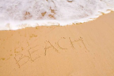 The word beach written with the finger in the sand, seashoreの写真素材