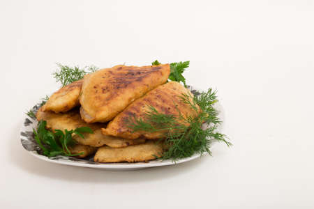 Fried pasties with herbs in a dish on a white backgroundの写真素材