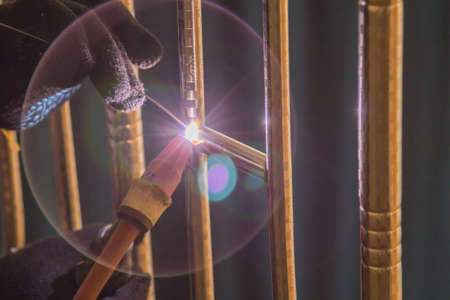 Welder TIG welds fences made of polished stainless steel