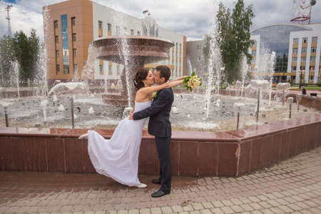 The bride and groom posing for the camera on the background of the urban landscapeの写真素材