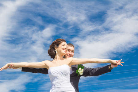 The bride and groom posing for the camera on the background of the urban landscapeの写真素材