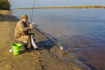 Fisherman caught fishing rod on earthworm big roachの写真素材