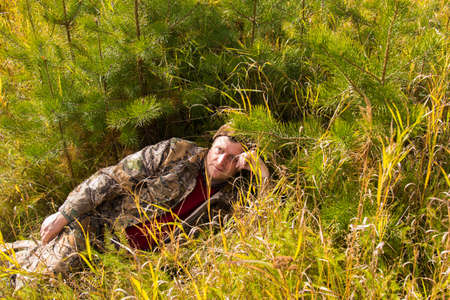 Portrait of a Man in a forest on the background of pine branchesの写真素材