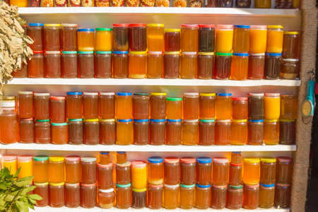 Fresh flower honey is bottled in glass jars and put up for saleの写真素材