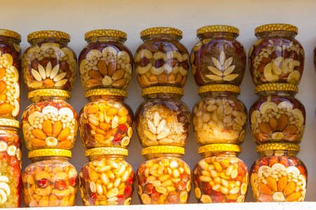 Fresh flower honey is bottled in glass jars and put up for saleの写真素材