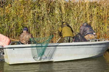 Three fishermen catch fish on spinners in the Volga delta