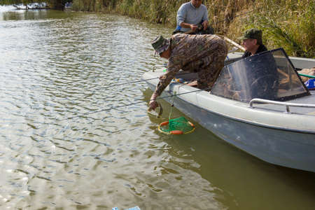 Three fishermen catch fish on spinners in the Volga delta