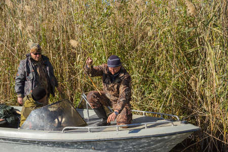 Three fishermen catch fish on spinners in the Volga deltaの写真素材