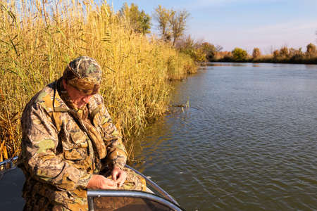 Fisherman sitting in the boat and prepare for the upcoming fishing tackleの写真素材