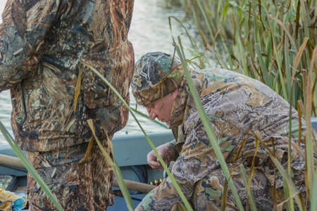 Fisherman sitting in the boat and prepare for the upcoming fishing tackleの写真素材