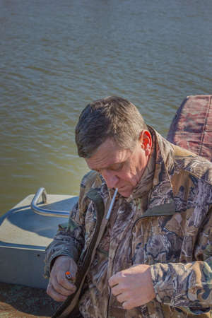 Fisherman sitting in the boat and prepare for the upcoming fishing tackle