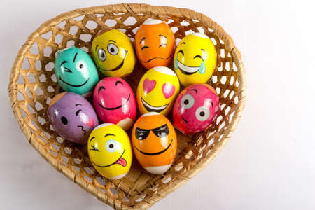 Wicker straw basket with Easter eggs isolated on white backgroundの写真素材