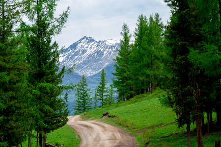 Country dirt road passes near the mountains