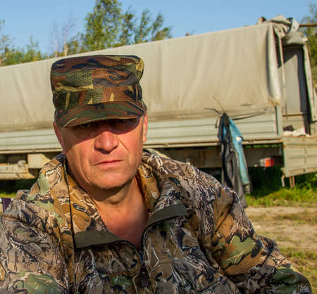 Portrait of a fisherman in camouflage uniforms at dawn
