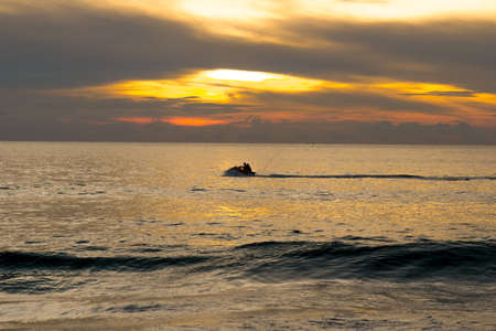 Evening on the sea and the sun gradually disappearing behind the horizonの写真素材