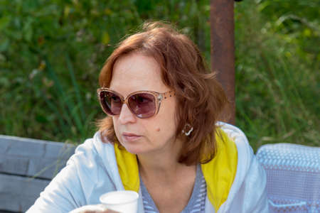 Portrait of a woman in glasses on the natureの写真素材