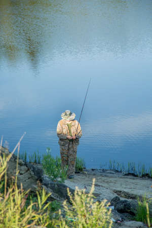 The fisherman catches a pike for spinning off the bank of the channel