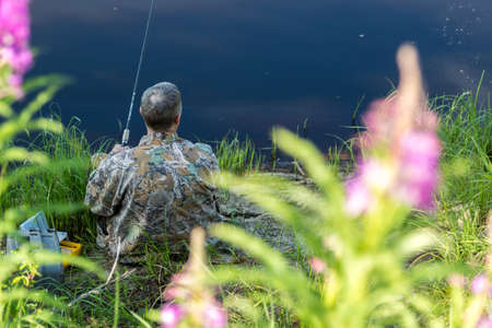 The fisherman catches a pike for spinning off the bank of the channelの写真素材