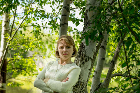 Portrait of a girl in a white blouse outdoorsの写真素材