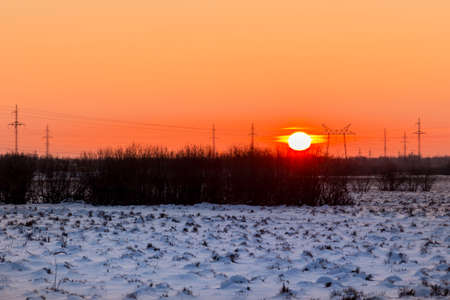 December early sunset against the background of a floodplain covered with snowの写真素材