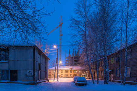 On a winter night in December in the city's slums, where there are lighted lamppostsの写真素材