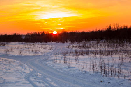 Sunset over the winter roadの写真素材