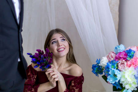 Young man and girl with a bouquet of blue flowers on a white backgroundの写真素材