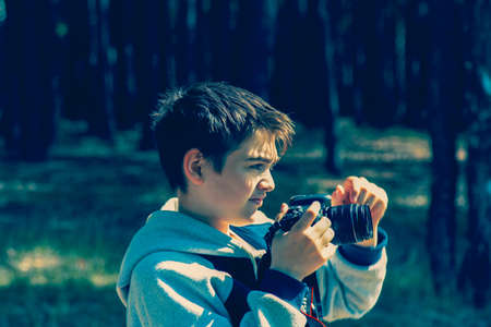 A boy with a camera learns to photograph a natural landscapeの写真素材