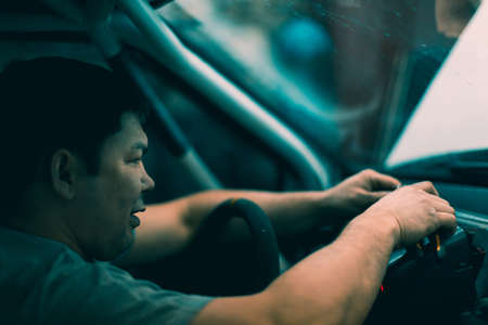 The mechanic in the workshop is engaged in repairing the carの写真素材