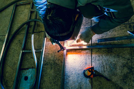 The welder lights the arc and begins to weld the metal structure of stainless steelの写真素材